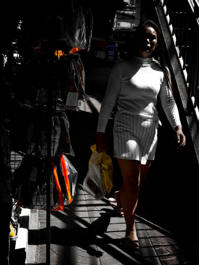 Into the Light · Bangkok, Thailand Woman walking through a shaft of sunlight on a Bangkok street.